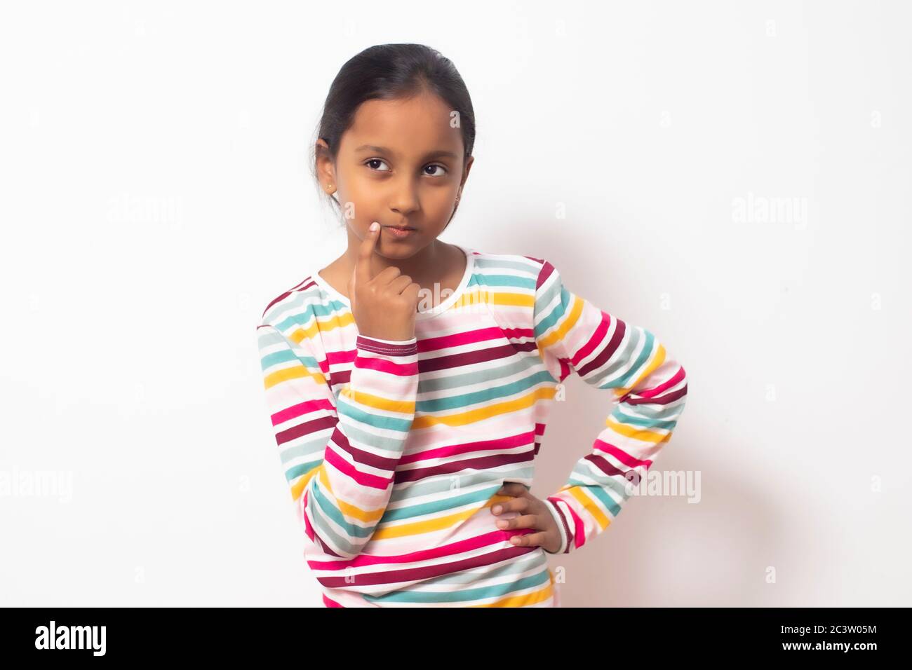 Cute brown skin child girl thinking concept. Wearing colorful long sleeve. Stock Photo
