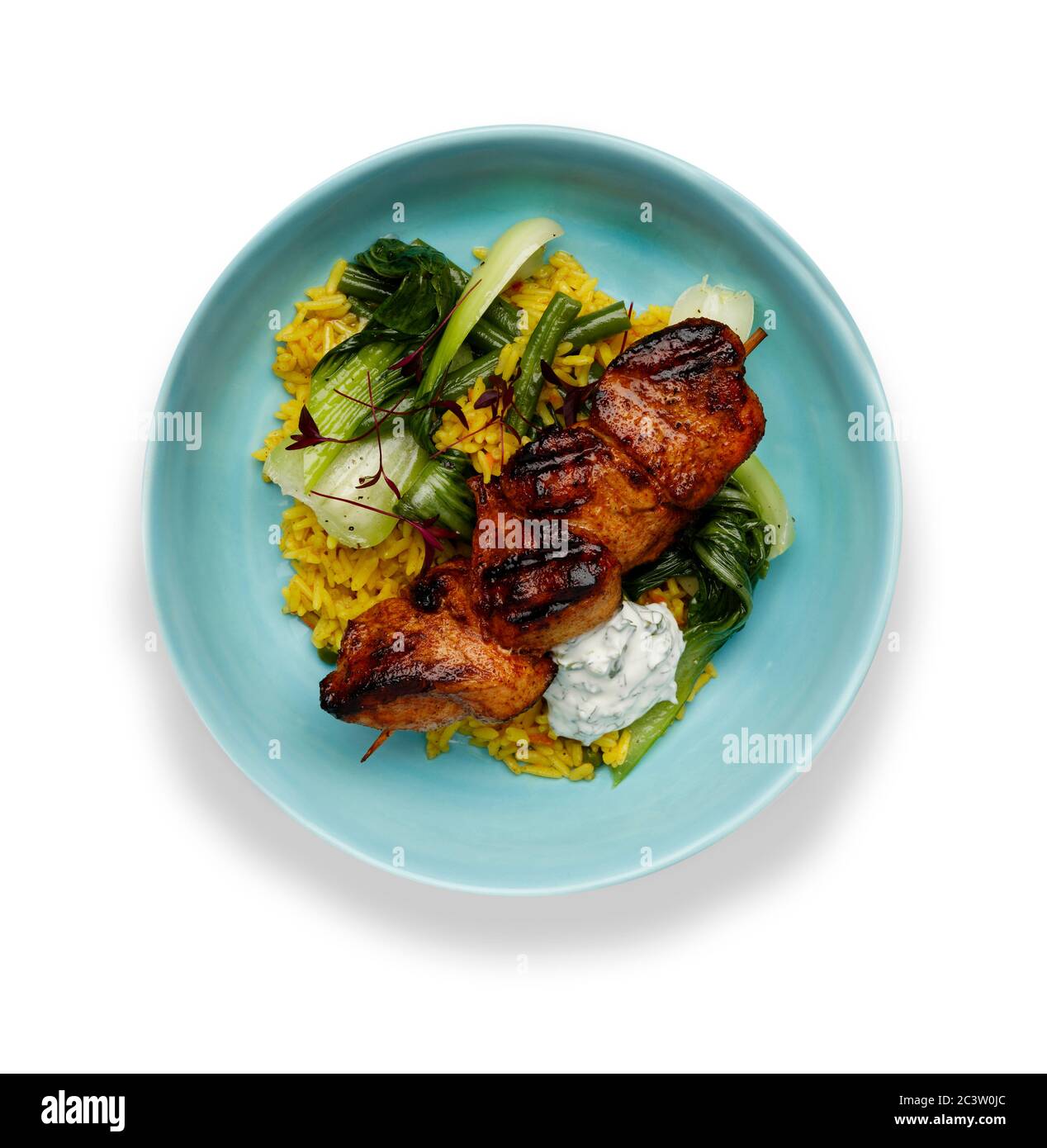 A delicious bowl of  tandoori chicken, vegetables and rice, in a light blue bowl isolated on a white background Stock Photo