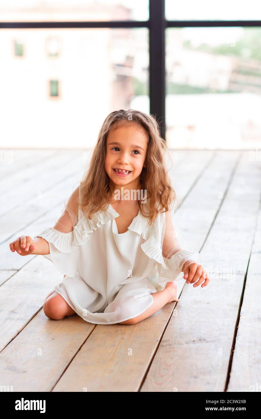 Charming little girl with infantile cerebral paralysis trying to sit and dance. Infantile cerebral paralysis disease concept Stock Photo