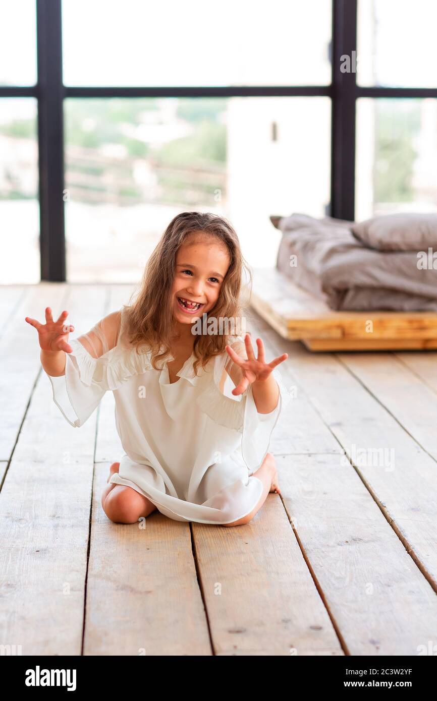 Charming little girl with infantile cerebral paralysis trying to sit and dance. Infantile cerebral paralysis disease concept Stock Photo