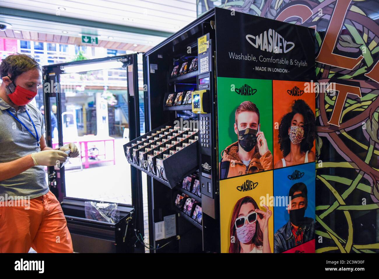 London, UK.  22 June 2020.  A staff member loads a vending machine in Carnaby Street selling facemasks to the public by London-based company Maskey.  Established by entrepeneur Adam Freeman to address the demand for affordable UK-made facemasks during the ongoing coronavirus pandemic, the newly established company is installing the UK's first fashionable face mask vending machines in locations around London, with plans to expand further.  10% of the profit from each facemask sale is donated to a charity supporting the NHS.    Credit: Stephen Chung / Alamy Live News Stock Photo