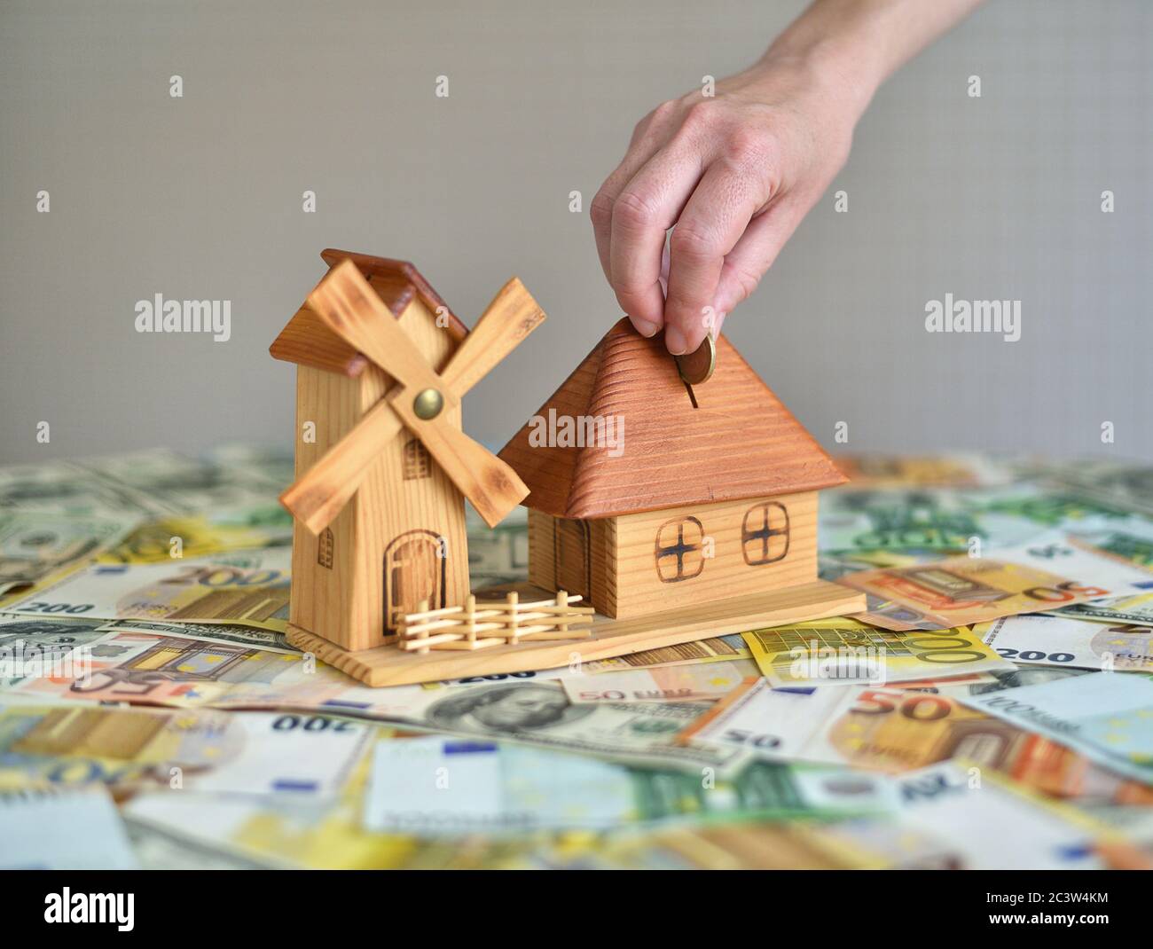 Hand Putting Coin In money box Stock Photo
