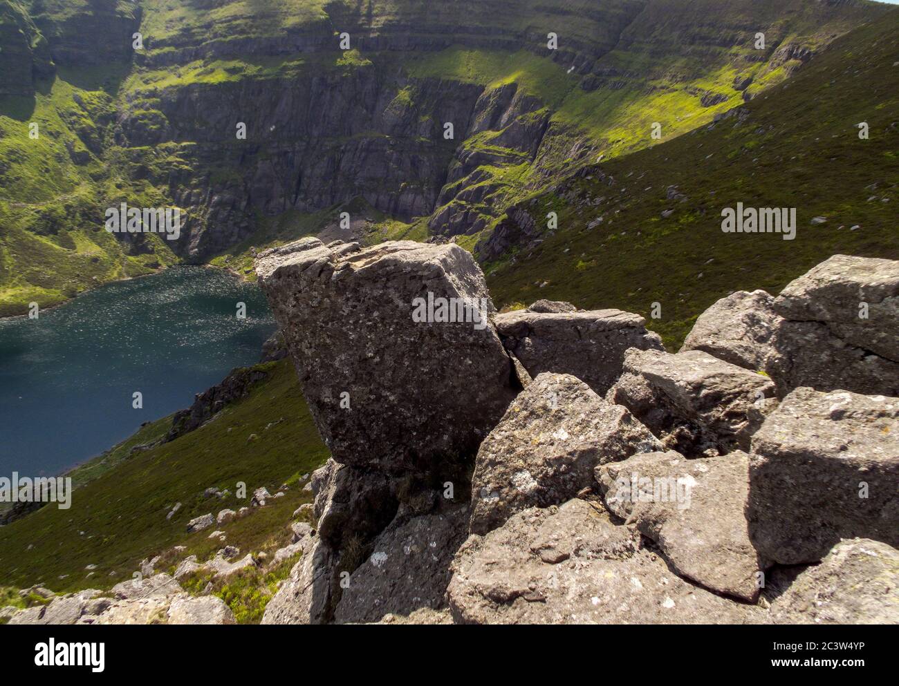 Steep cliffs flowing into the mountain lake Stock Photo