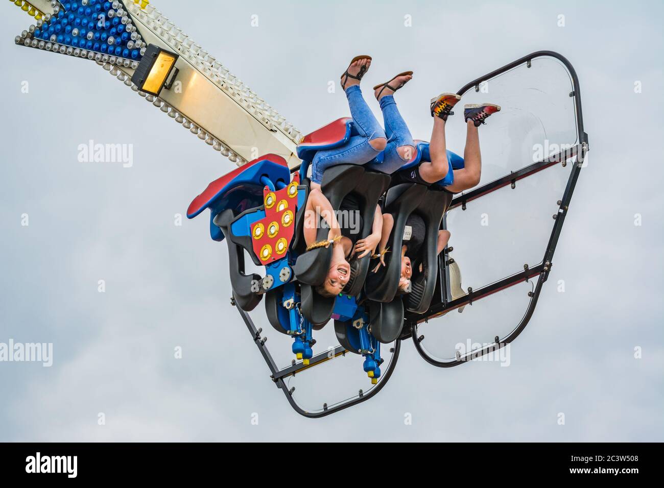 Youngsters upside-down on the Oxygen fairground ride at a funfair in the UK. Stock Photo