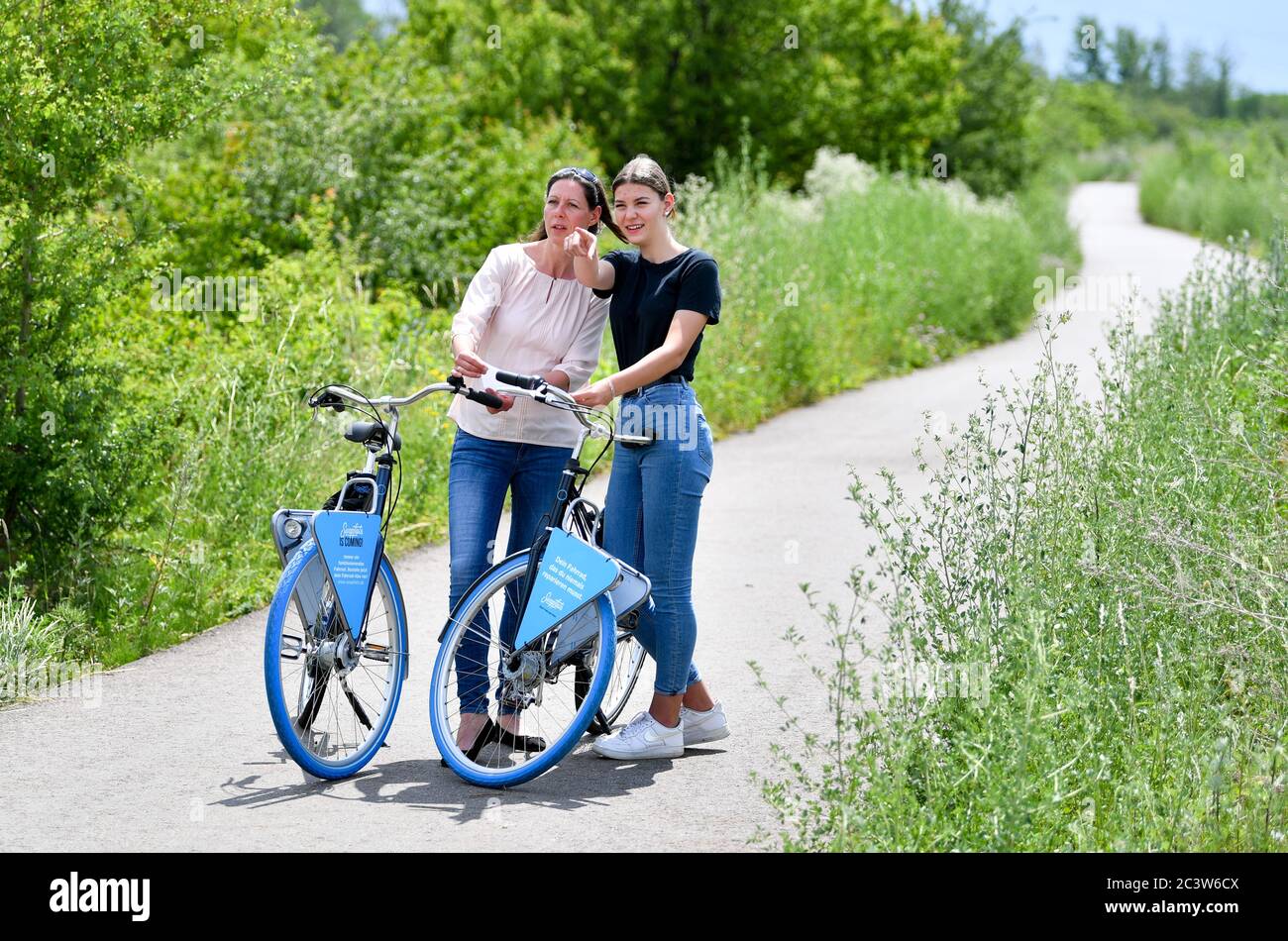 22 June 2020, Saxony-Anhalt, Halle (Saale): Women cyclists look at the route  of a cycle path on the outskirts of the city. Representatives of the cities  of Leipzig and Halle and of
