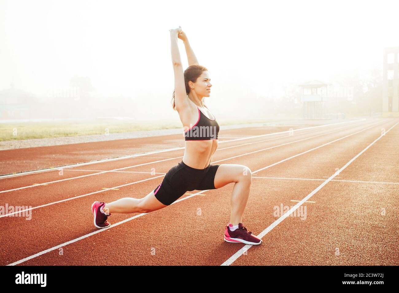 Athletic woman stretching on running track before training, healthy fitness lifesty Stock Photo