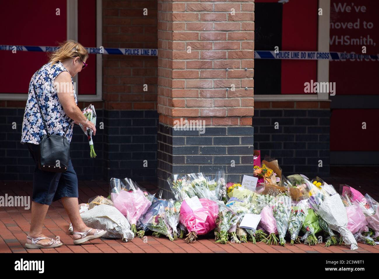 A woman lays flowers near Forbury Gardens, in Reading town centre, the scene of a multiple stabbing attack which took place at around 7pm on Saturday, leaving three people dead and another three seriously injured. Stock Photo