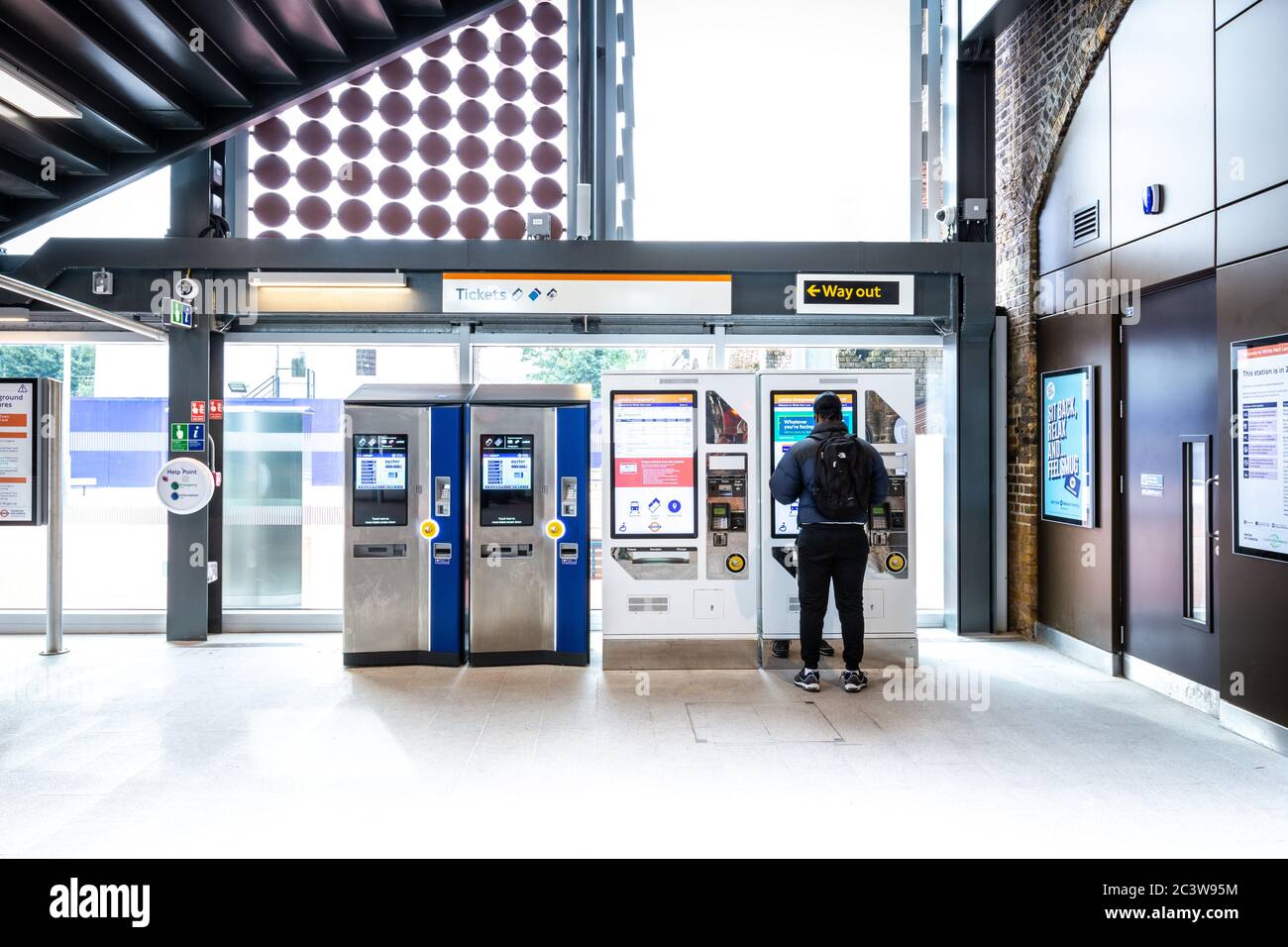 A person using one of the ticket machines at White Hart Lane Overground
