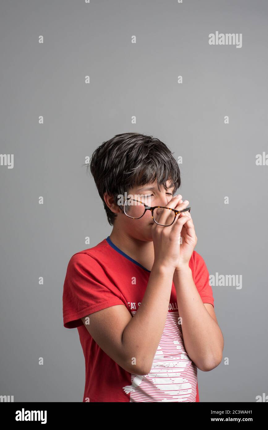 Young boy with cross yeyed vision holds correction glasses Stock Photo