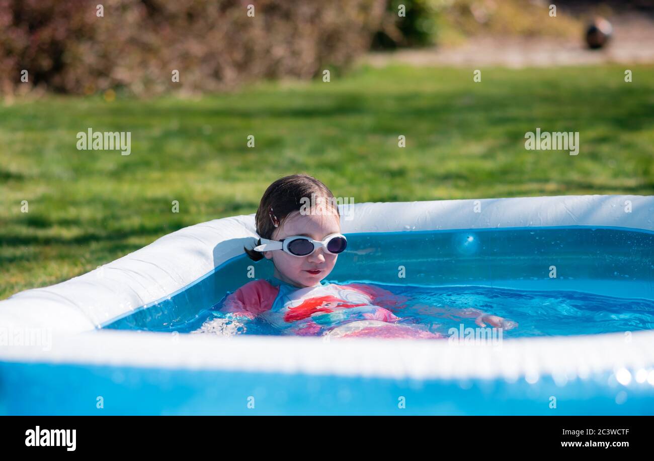 Little girl relaxes in outdoor paddling pool Stock Photo Alamy