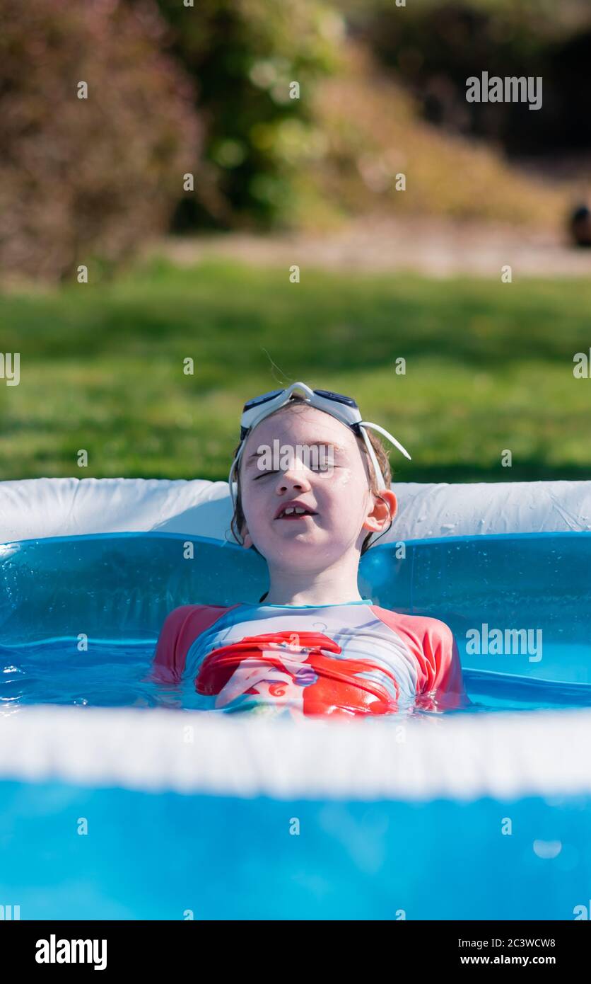 Little girl relaxes in outdoor paddling pool Stock Photo