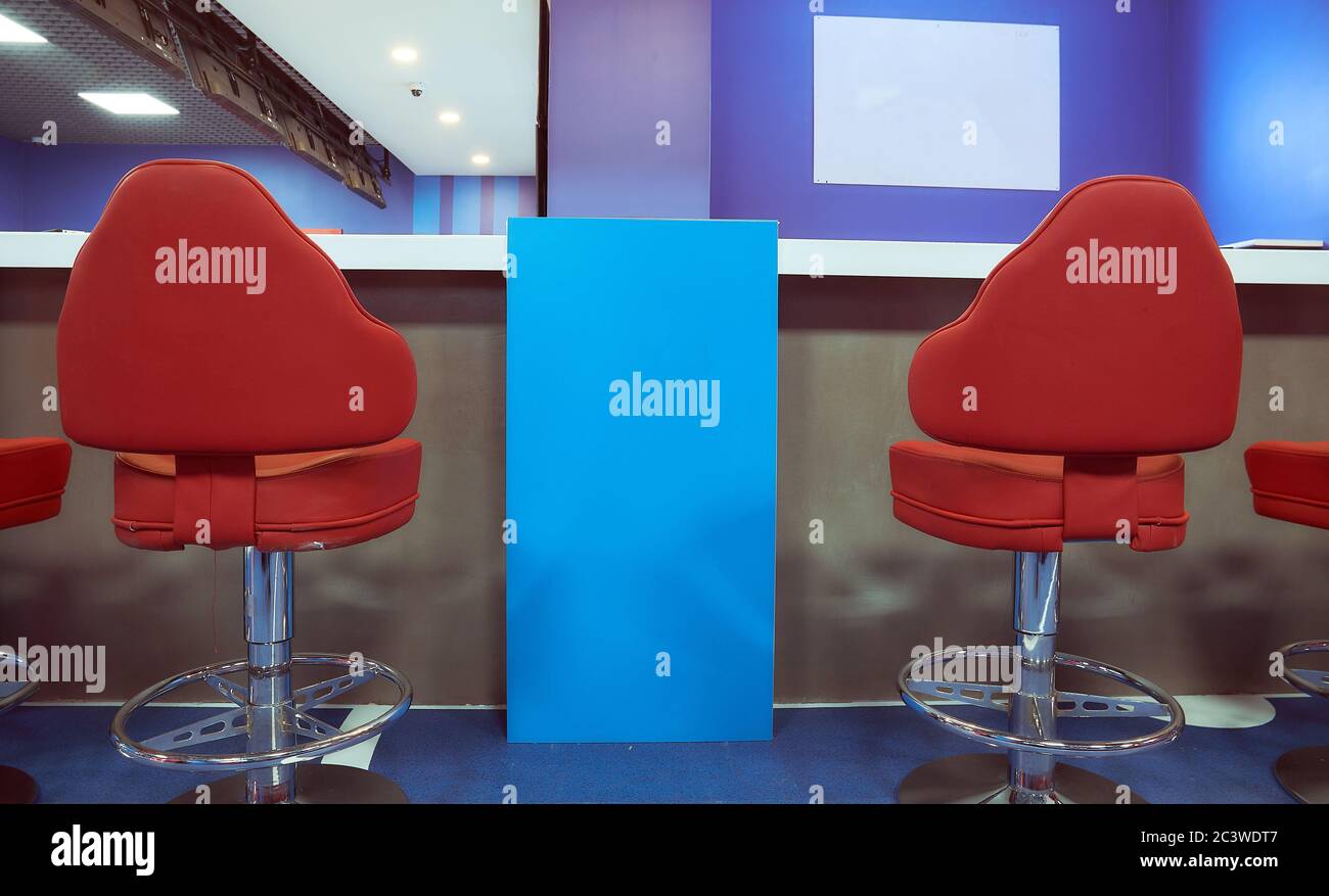 Two red bar stools in a blue interior Stock Photo - Alamy