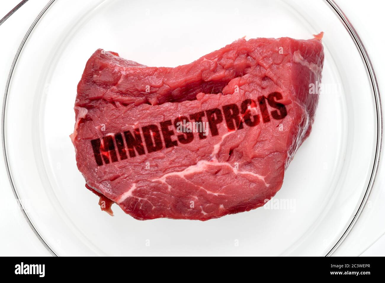 PHOTOMONTAGE, meat labeled minimum price on a plate, FOTOMONTAGE, Fleisch mit der Aufschrift Mindestpreis auf einem Teller Stock Photo