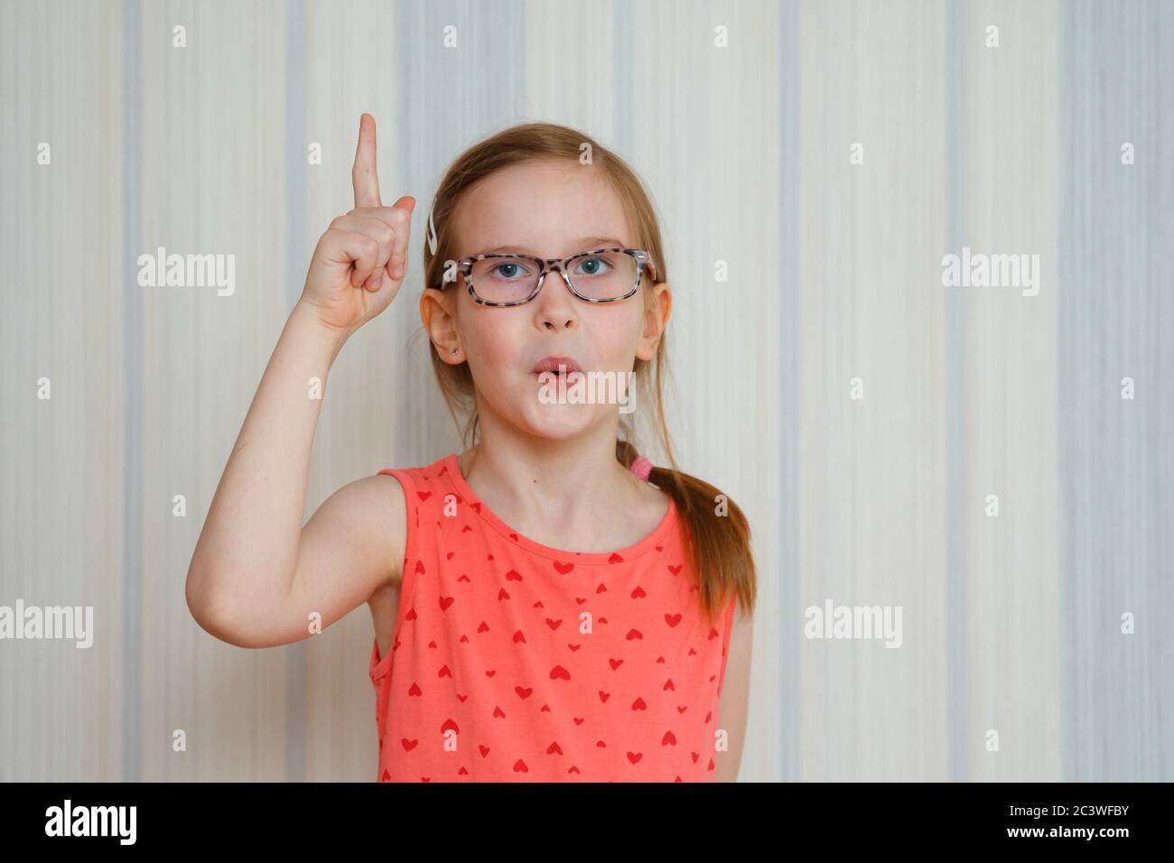 Little girl make gesture raises finger came up with creative plan feels excited with good idea, eureka concept Stock Photo