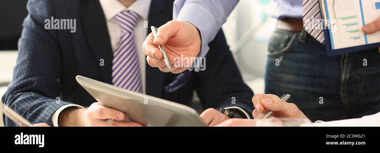 Male hand pointing in tablet pc during business meeting Stock Photo