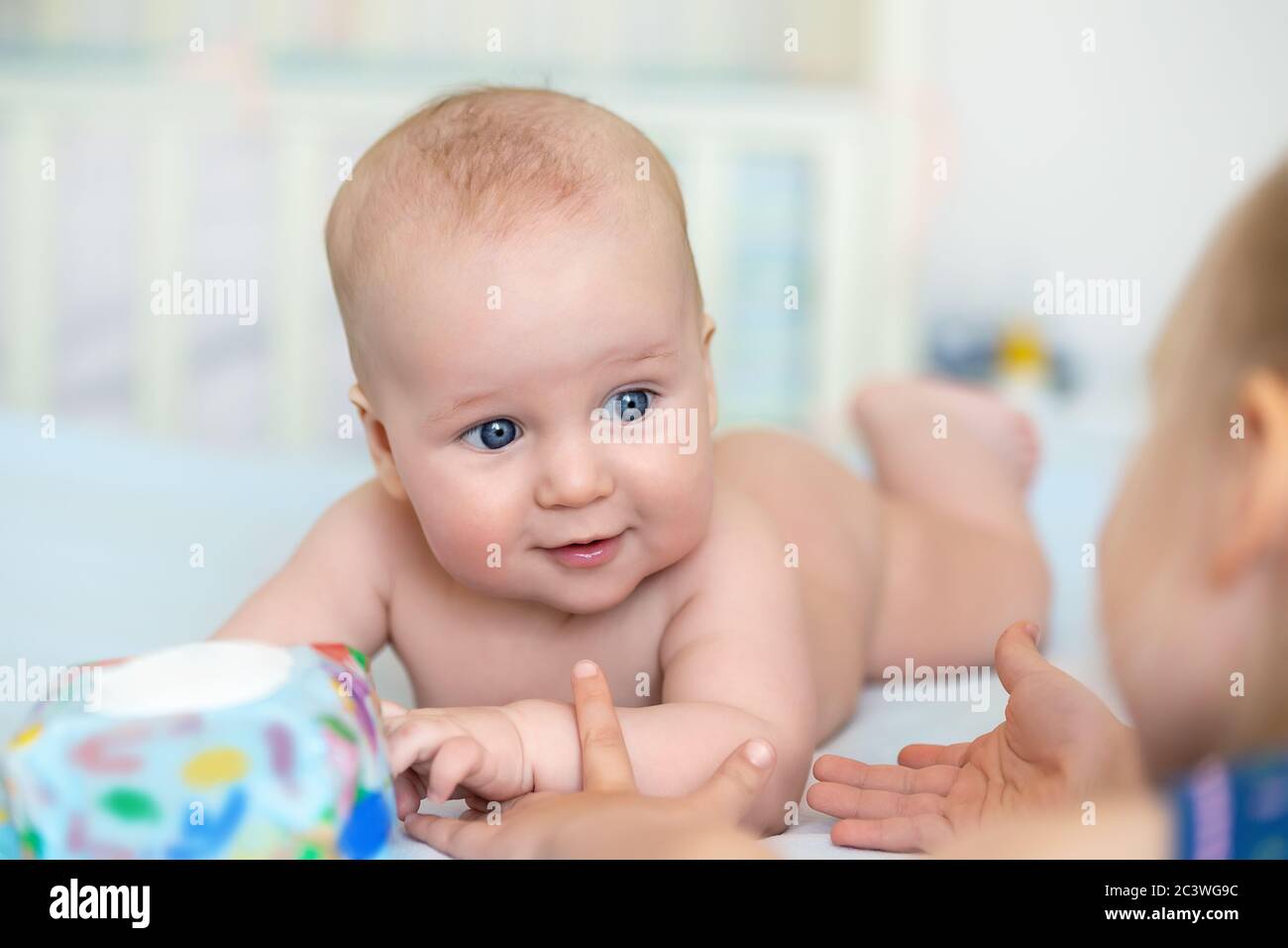 Cute Adorable Caucasian Little 5 Month Old Infant Baby Boy Lying On Tummy At Nursery Bed Room 