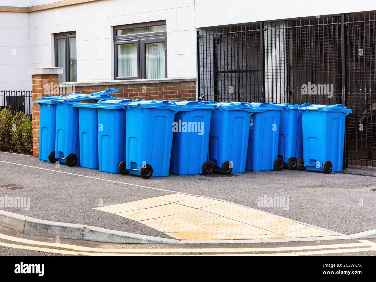 may blue wheelie bins outside a block of flats or apartments used for
