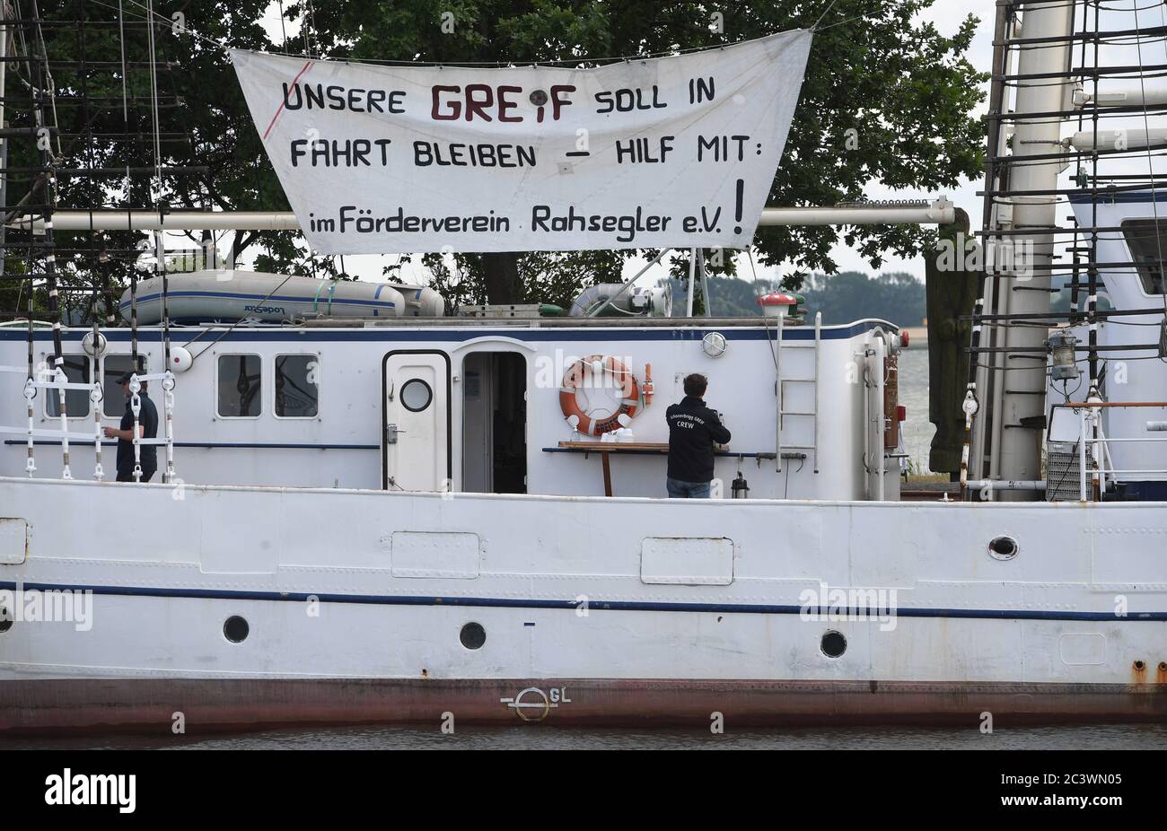 Greifswald Wieck, Germany. 22nd June, 2020. A poster with the writing 'Our Greif shall stay in motion' hangs on the sailing ship Greif in the port of Greifswald-Wieck. The 40-metre-long two-mast barque, built in 1951 as the GDR sailing training ship 'Wilhelm Pieck', is to be renovated. A redevelopment concept for this is now available. Credit: Stefan Sauer/dpa-Zentralbild/dpa/Alamy Live News Stock Photo