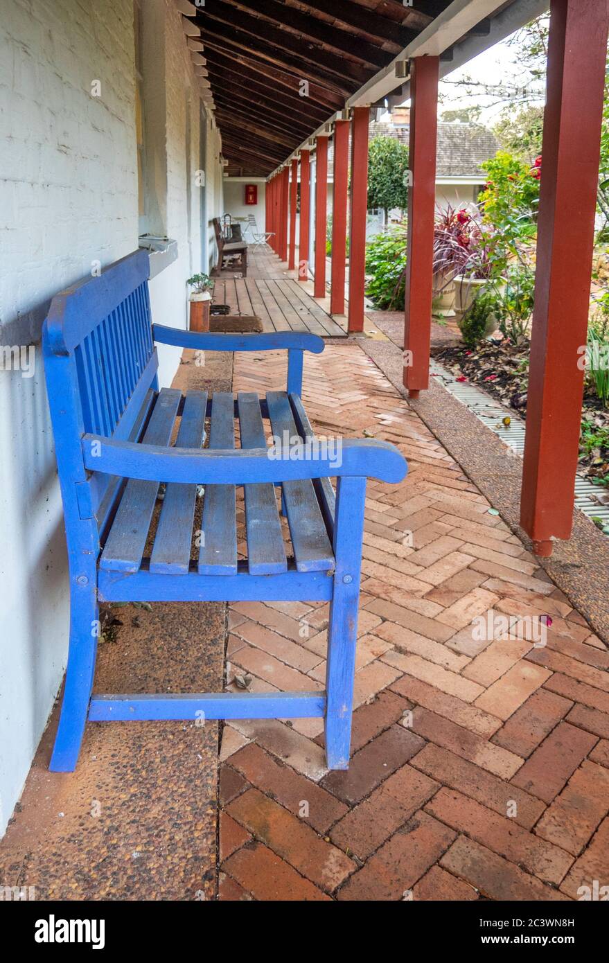 Blue wooden bench under a verandah of a rustic farmhouse in Southwest