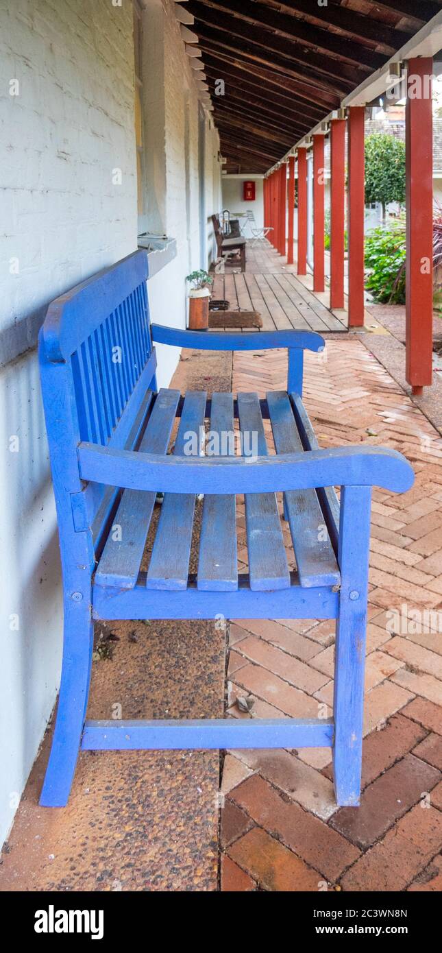 Blue wooden bench under a verandah of a rustic farmhouse in Southwest
