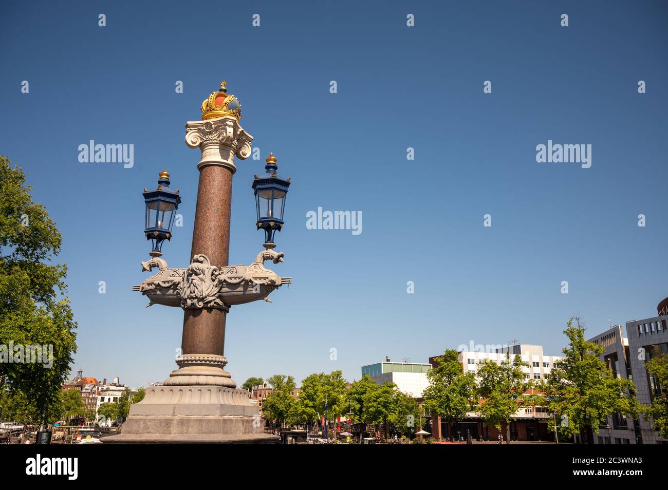 Adornments of royal crown on top of the pillar and lights on Blauwbrug over the river Amstel in Amsterdam, Netherlands Stock Photo
