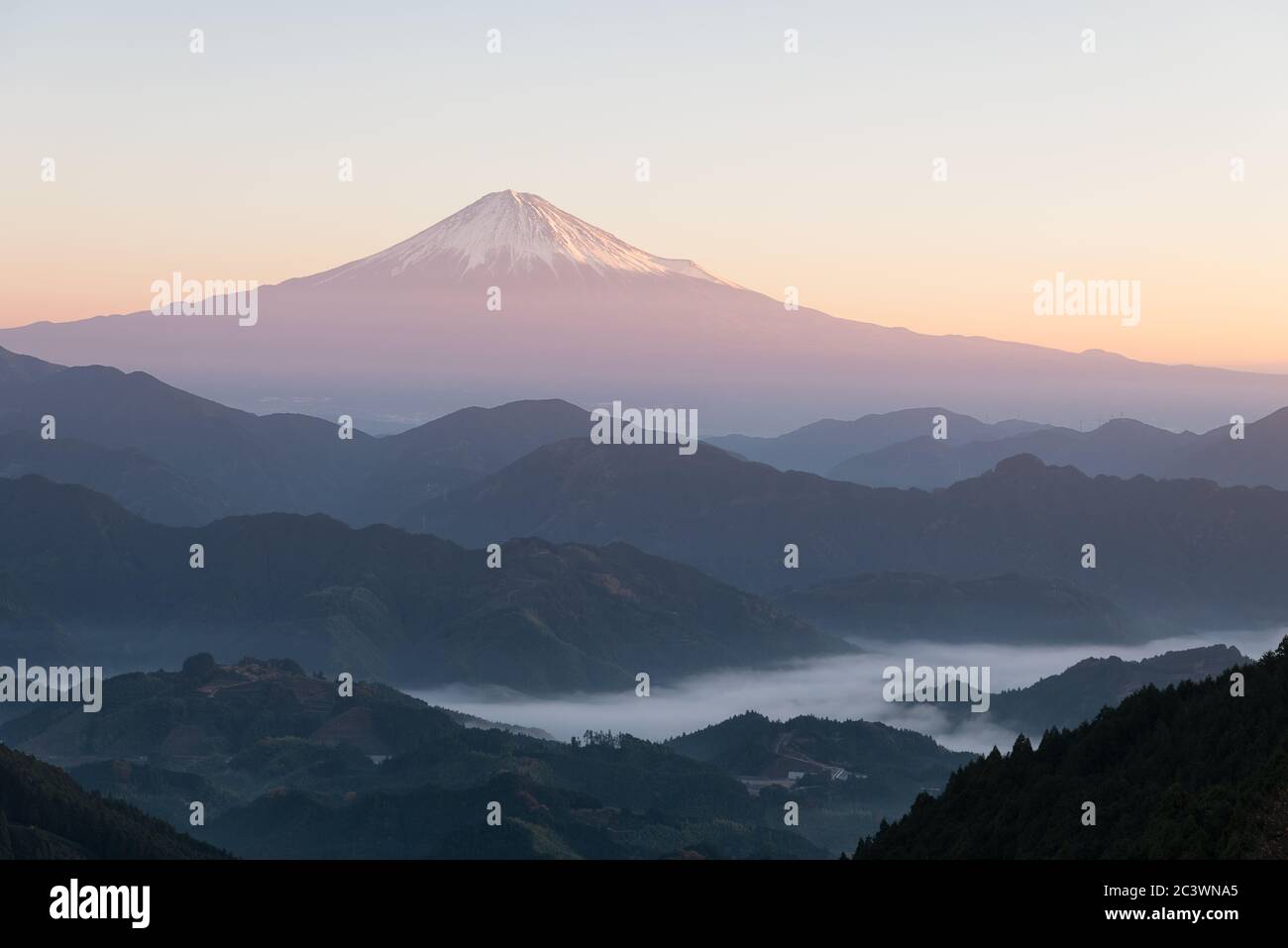 Mt. Fuji over Mountains in a Foggy Morning Stock Photo