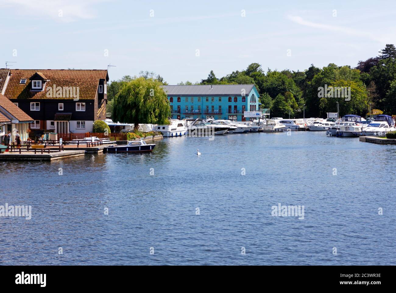 A view of the River Bure with boatyards on the Norfolk Broads at Wroxham, Norfolk, England, United Kingdom, Europe. Stock Photo