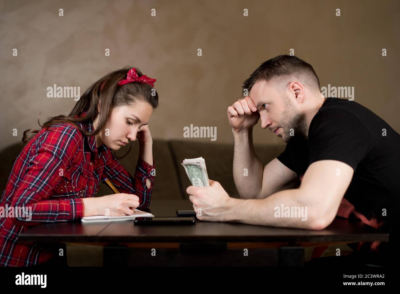 man holds money and watches wife calculate the budget. financial difficulties Stock Photo