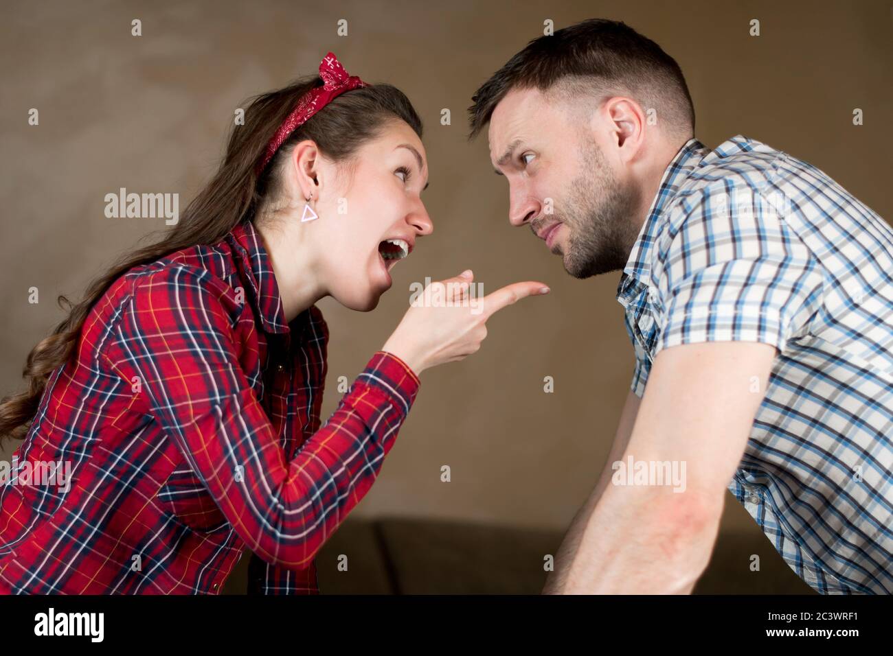 Husband and wife swear. Wife chastises husband for something, pointing finger Stock Photo
