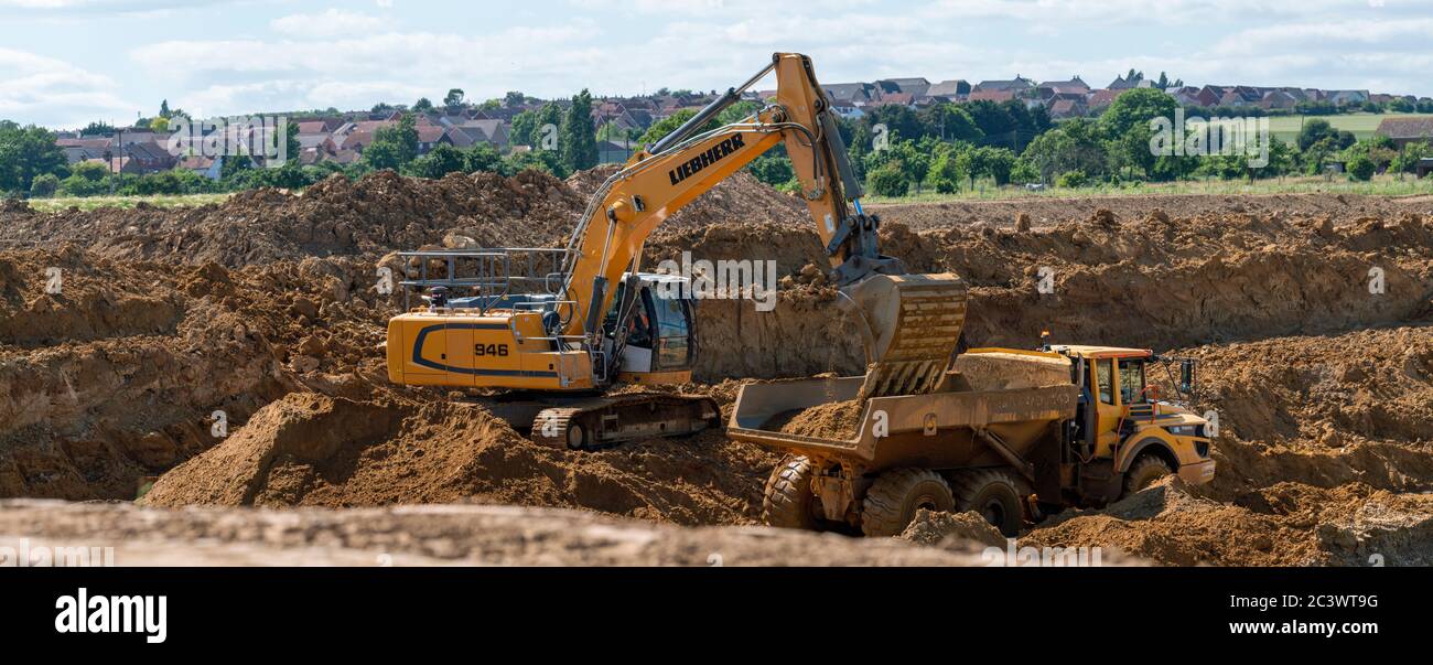 Phase 3 of the Kingsnorth Quarry, Hoo. The excavator digging and loading it's payload of gravel into a dump truck to be off loaded into the plant Stock Photo