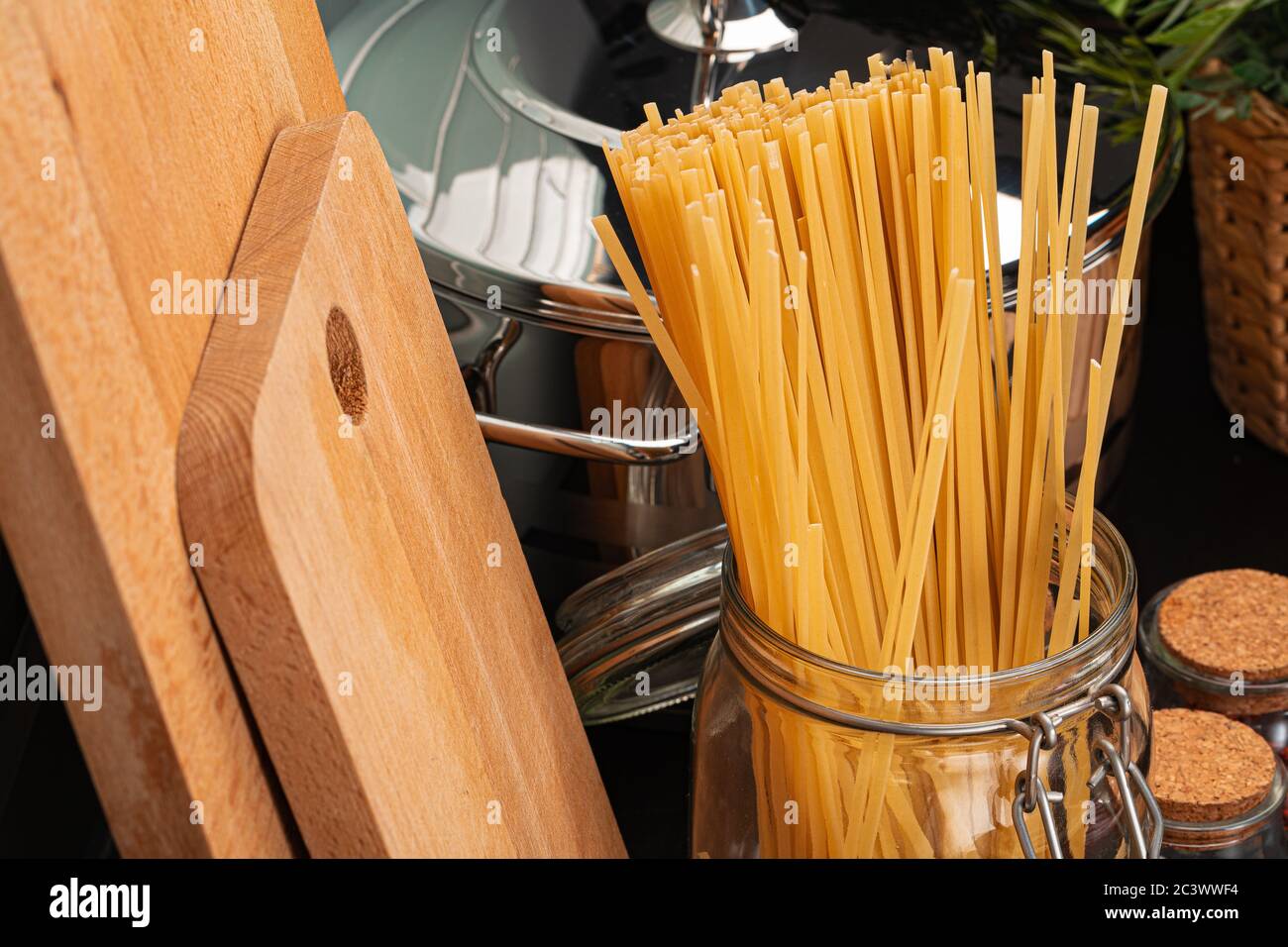 Dry spaghetti on a kitchen counter with cooking utensils Stock Photo