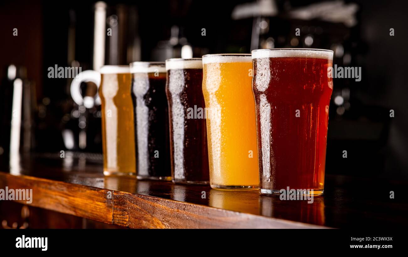 Many varieties of craft beer. Misted glass goblets with ale, lager, and unfiltered drink on bar Stock Photo