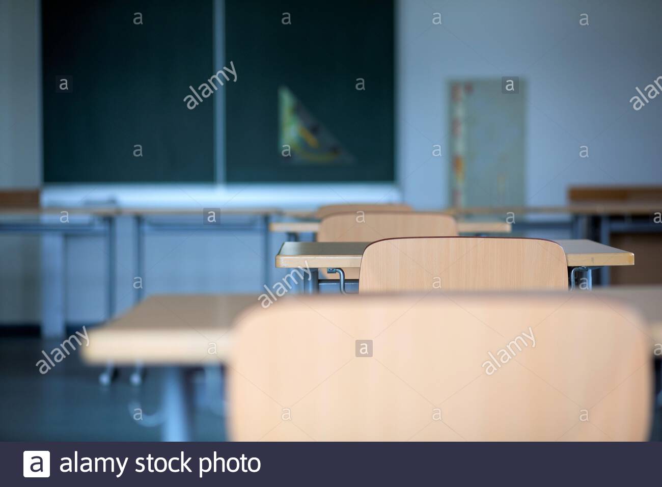 School desks and chairs in an empty classroom in Germany as the corona crisis continues to hit education hard. Stock Photo