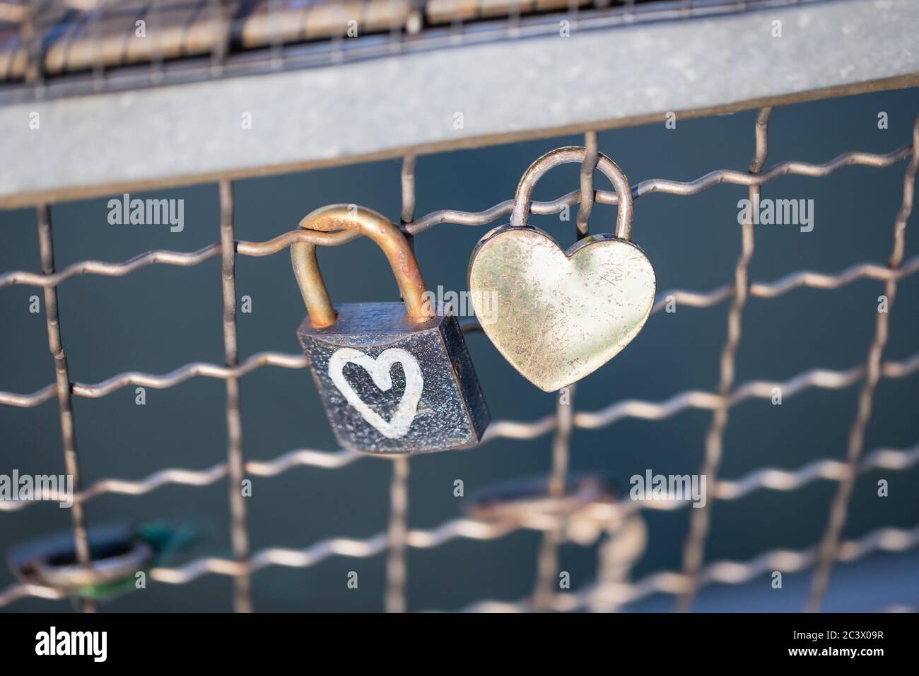 Two old rusty padlocks with heart on the bridge Stock Photo
