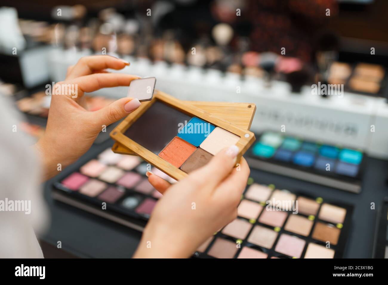 Woman holds eyeshadows at shelf in cosmetics store Stock Photo Alamy