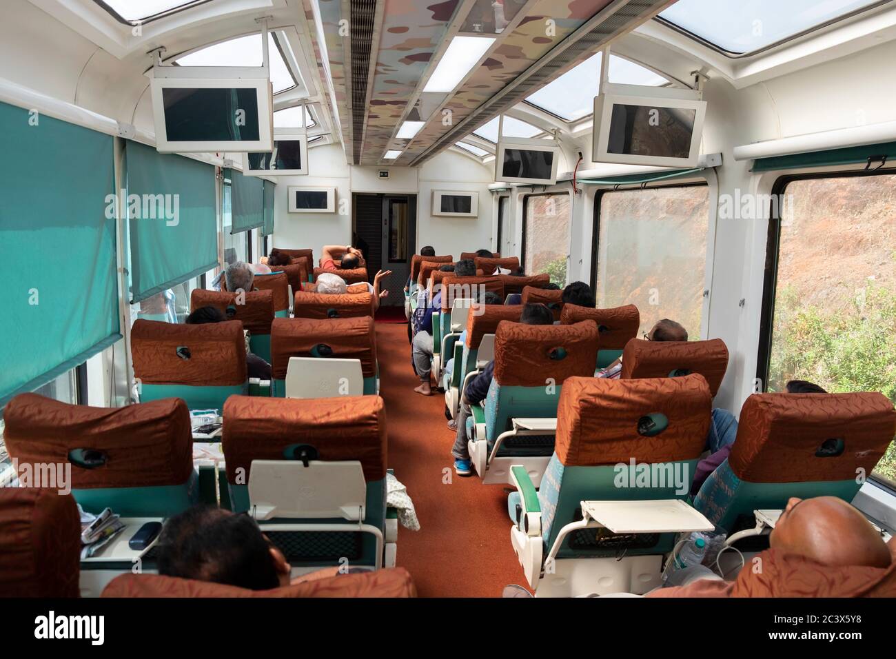 Passengers inside the modern TEJAS EXPRESS train to Goa, India. Stock Photo