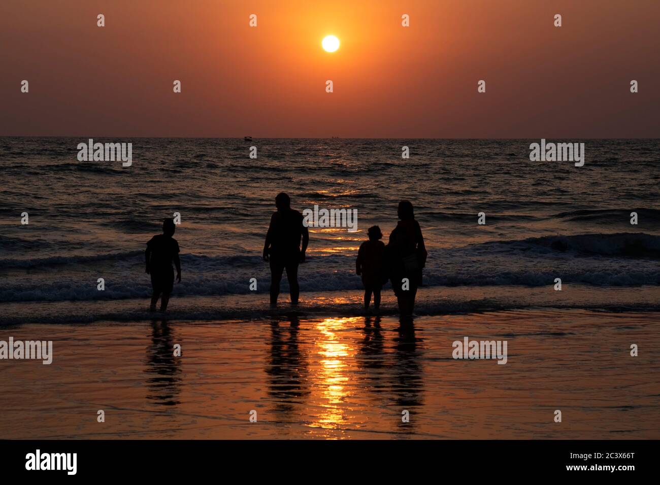 Silhouette of family on the beach at sunset at Majorda beach in Goa, India. Stock Photo
