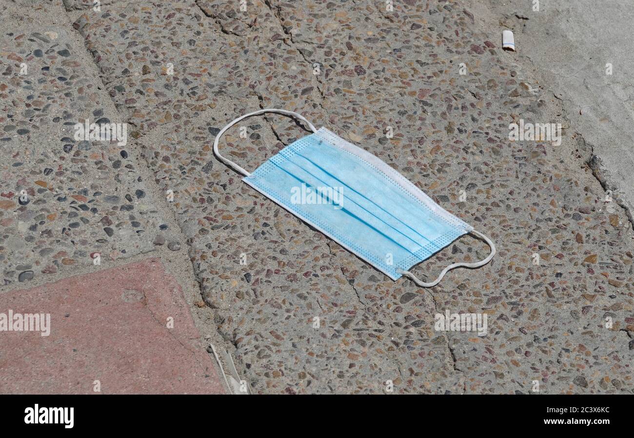 Discarded face mask littering the ground Stock Photo