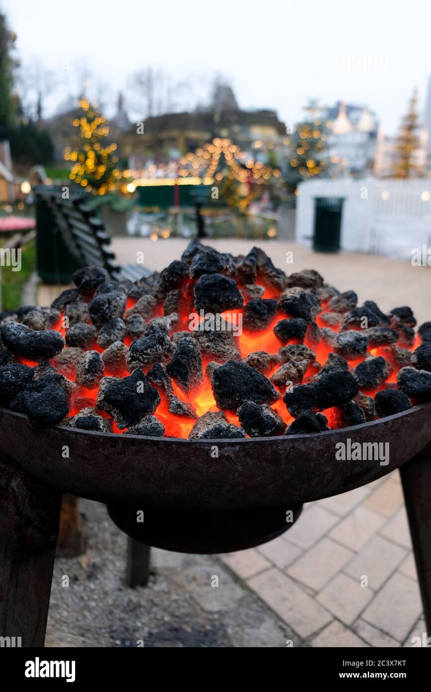 Cozy open fireplace in the yard outdoors at the Christmas Market called Tivoli Gardens in Copenhagen. Outside fire to warm up freezing hands in winter Stock Photo