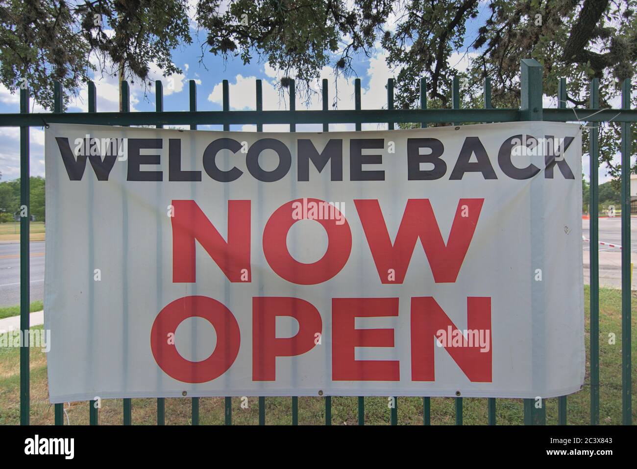 Welcome back now open sign showing businesses opening back up after covid 19 forced the shut down of the economy for months spiking cases. Stock Photo