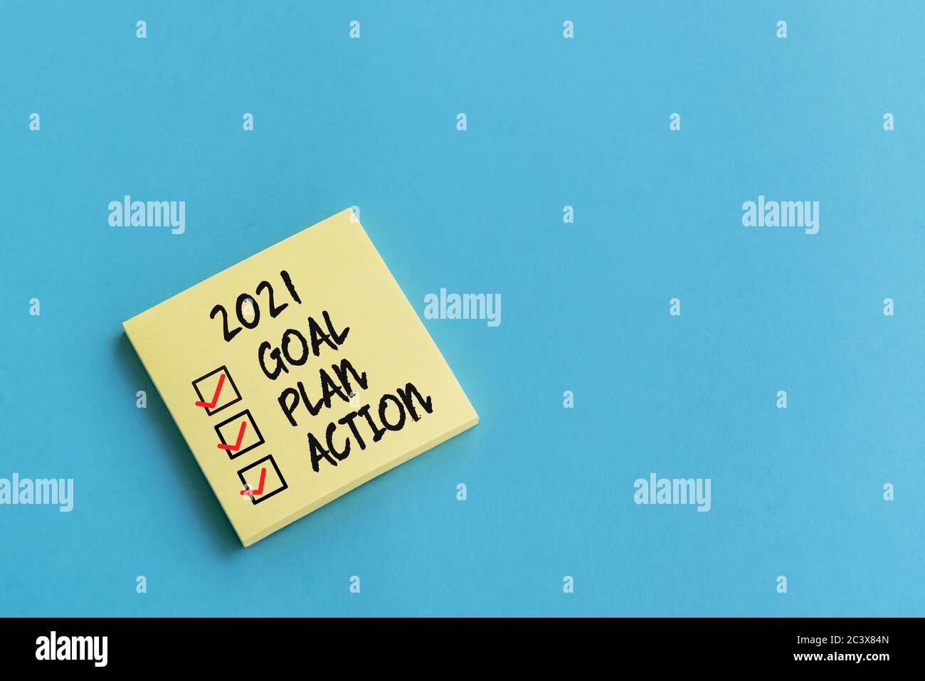 2021 goal, plan, action checklist text on adhesive note blue background Stock Photo