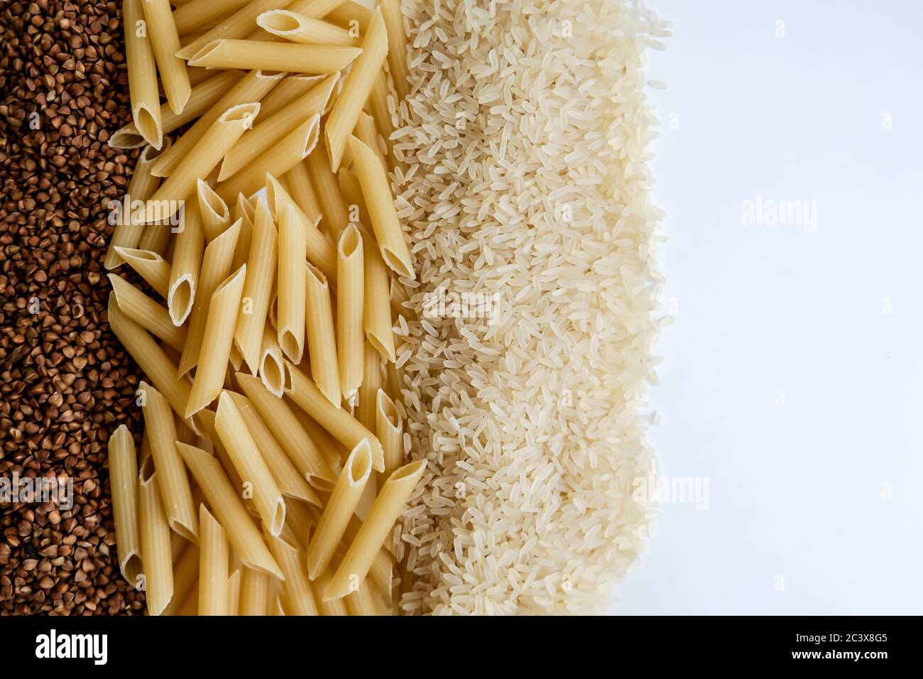 https://c8.alamy.com/comp/2C3X8G5/whole-grains-on-white-table-raw-buckwheat-pasta-rice-empty-space-for-copy-panic-buying-food-products-in-bulk-for-coronavirus-outbreak-isolation-2C3X8G5.jpg