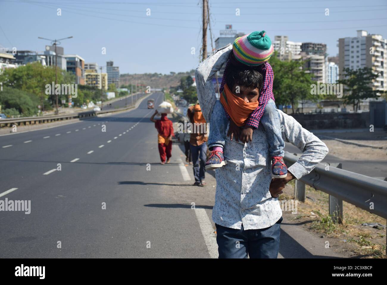 Ramesh Waskele, a Worker of a Toll Plaza of Kolhapur Walking on Pune Banglore Highway, Pune to go home in MP (714 KM) with his family in lockdown Stock Photo