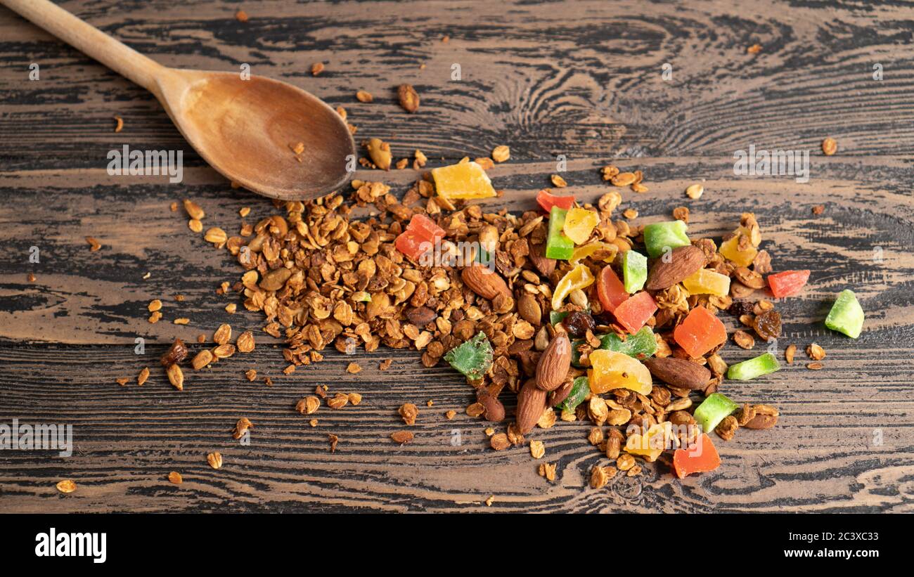 Rustic morning healthy food. Colored and bright background. Sweet flakes with nuts and fruits on brown wooden table Stock Photo