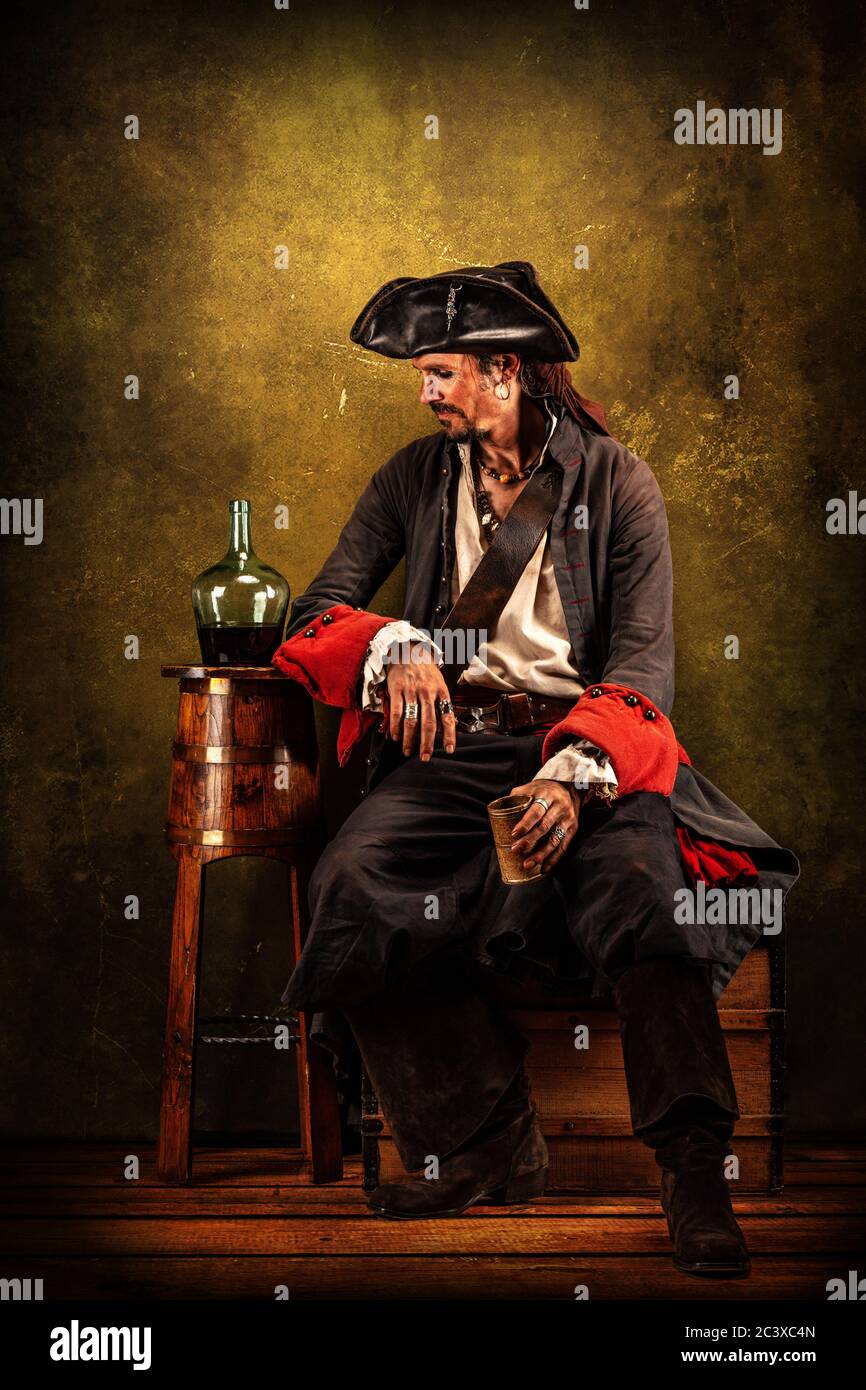 Portrait of a pirate drinking rum, sitting in a tavern Stock Photo Alamy