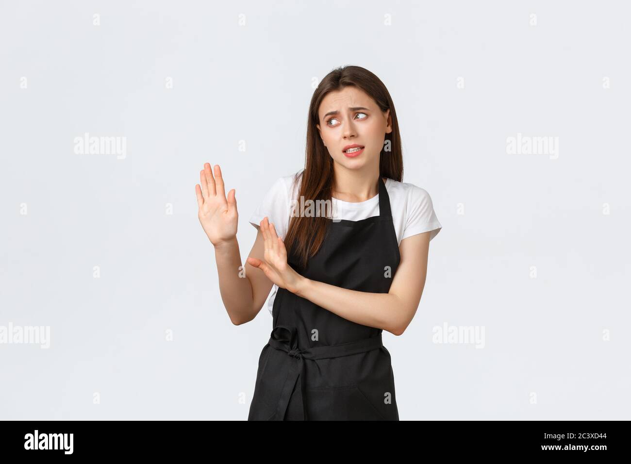 Grocery store employees, small business and coffee shops concept. Disgusted and reluctant barista avoiding strange guest. Displeased saleswoman Stock Photo