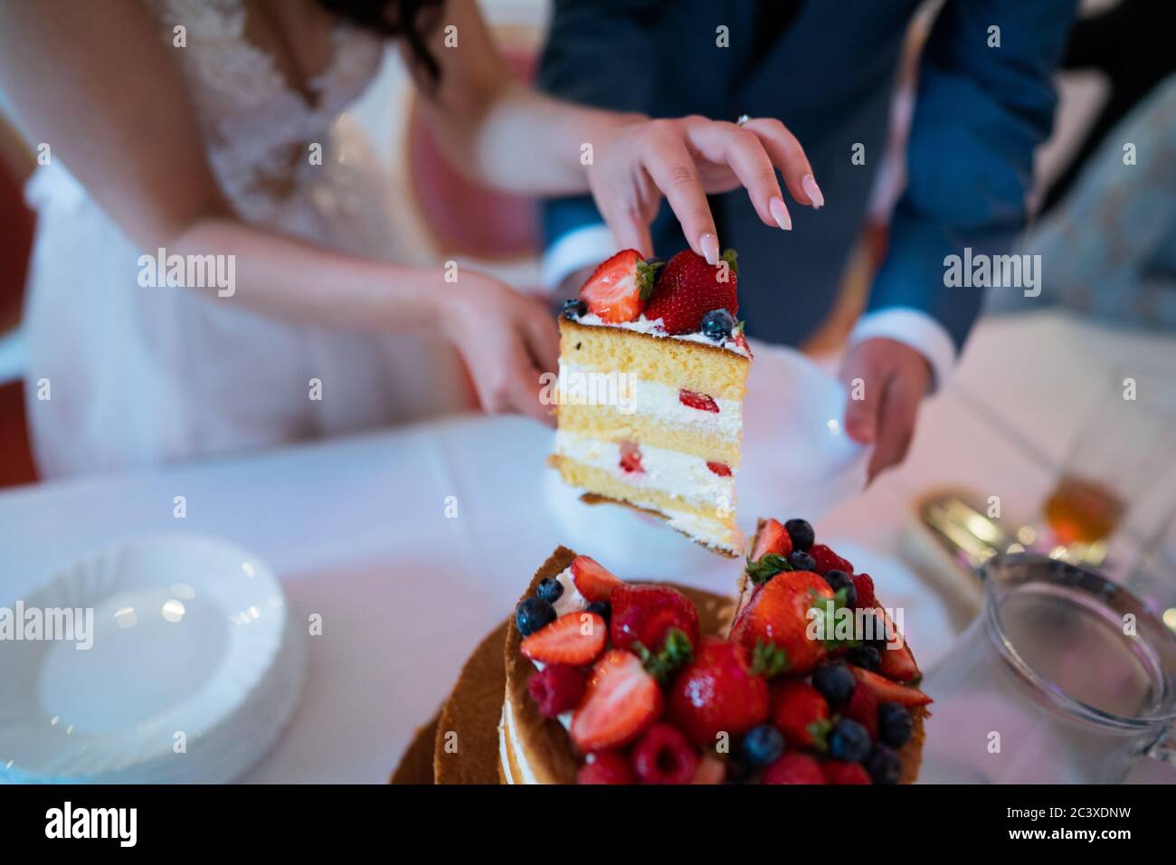 Newlyweds cutting a wedding cake Stock Photo