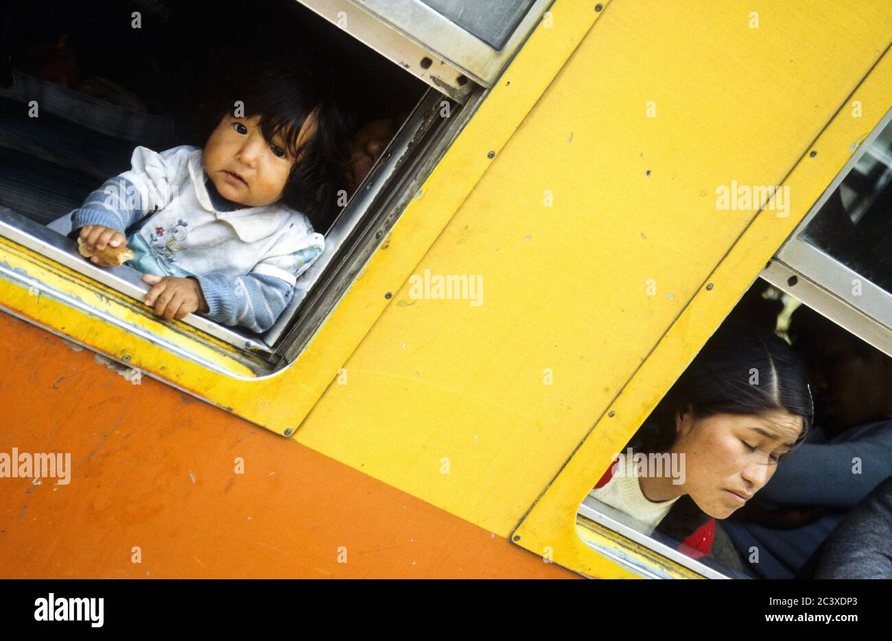 Curious kid and his mother in the train to Machu Pichu. Peru Stock Photo