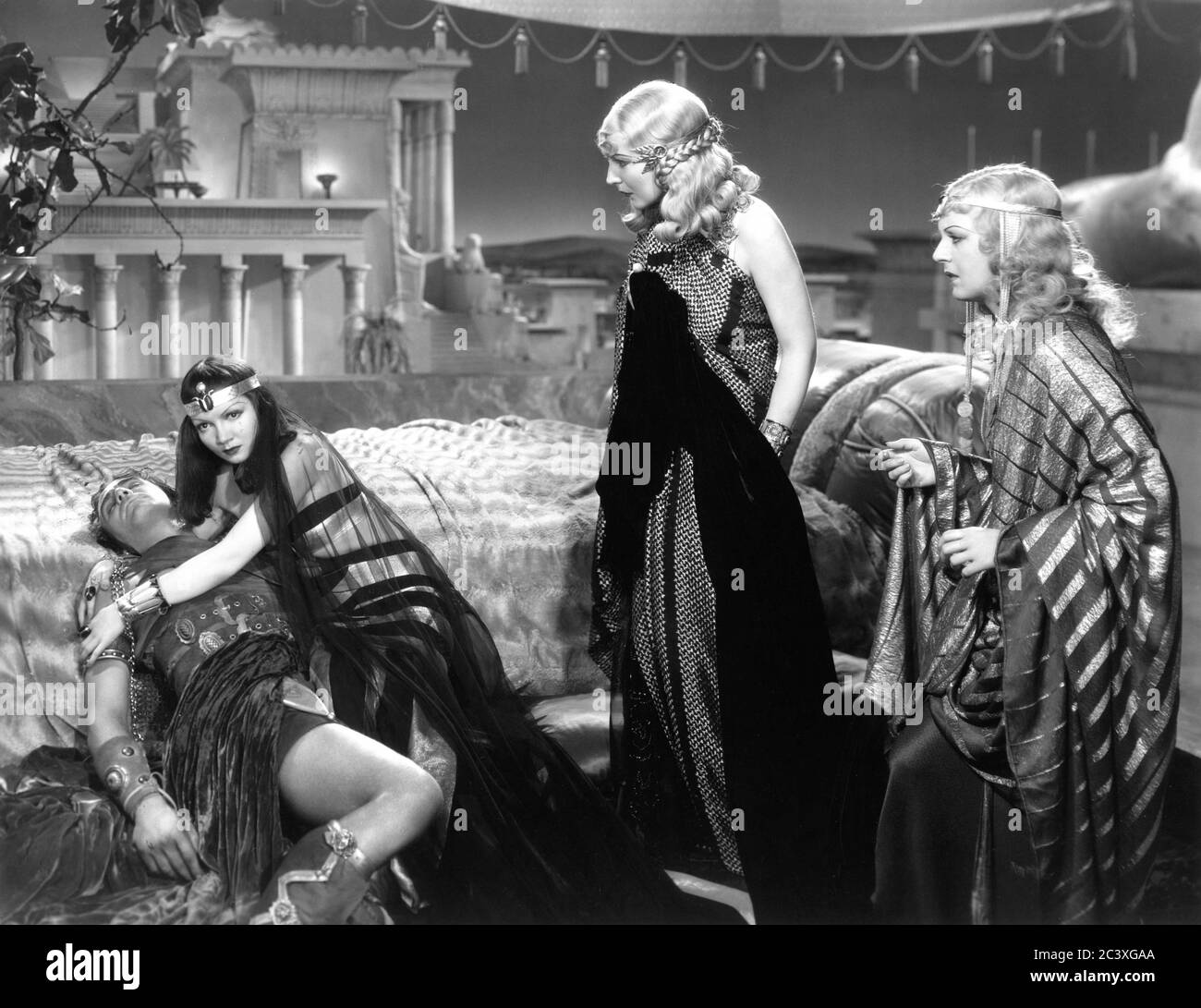 HENRY WILCOXON as dying Marc Antony CLAUDETTE COLBERT as Cleopatra ELEANOR PHELPS as Charmian and GRACE DURKIN as Iras in CLEOPATRA 1934 director CECIL B. DeMILLE Miss Colbert costume Travis Banton photo by Ray Jones Paramount Pictures Stock Photo