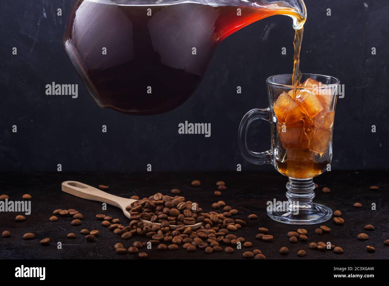 Cold coffee poured into a glass of ice with carafe Stock Photo